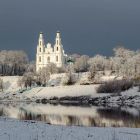 Белокаменный храм на берегу реки зимой